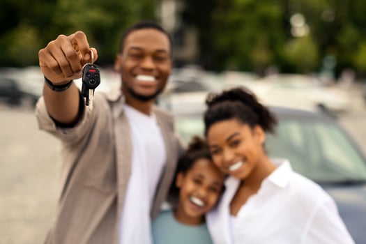 Car Purchase. Cheerful African American Family Holding Auto Key To Camera Standing Outside Near New Vehicle. Automobile Owners Concept. Selective Focus On Keys photo