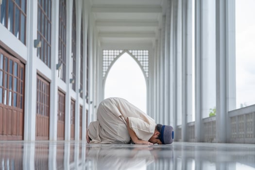 A little Asian Muslim boy is praying with peace in the beautiful mosque, islam concept. photo