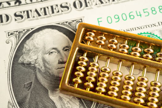 Gold abacus on US dollar banknote money, economy finance exchange trade investment. photo