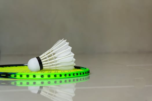 Badminton sport rackets and shuttlecocks on green background. copy space photo