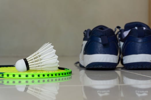 Set of badminton equipment with rackets, shoe, and shuttlecocks on a floor photo