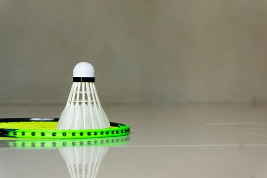 racket and shuttlecock on the floor, copy space photo