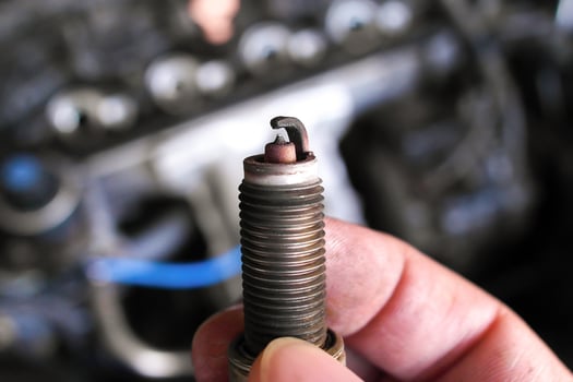 Close up of used spark plug in hand , car spark plug for engine ignition system , Automotive parts concept photo