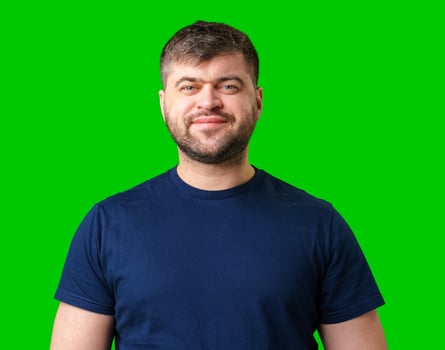 Smiling man wearing a blue shirt poses in front of a bright green background photo