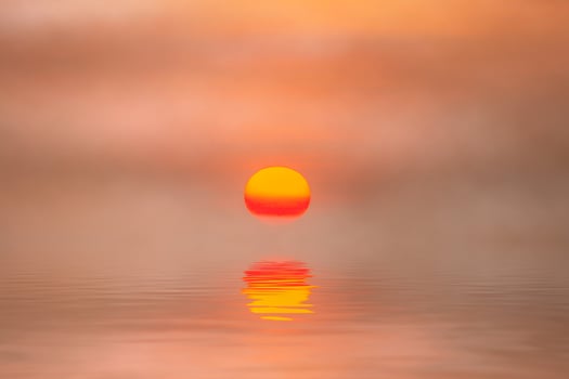 Sunset reflection at the lake with soft mist. photo