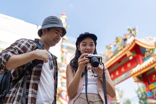 Traveling couple captures memories at cultural festival vibrant streets outdoor joyful experience photo
