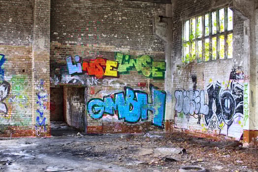 Corner of an abandoned factory hall with graffiti and waste photo