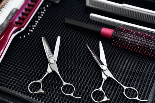 Quality hair scissors and styling tools arranged on a salon table photo