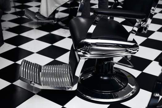 Classic barber chair in a black and white checkered salon setting photo