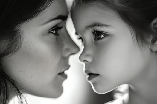 Intimate moment between mother and daughter captured in soft monochrome light photo