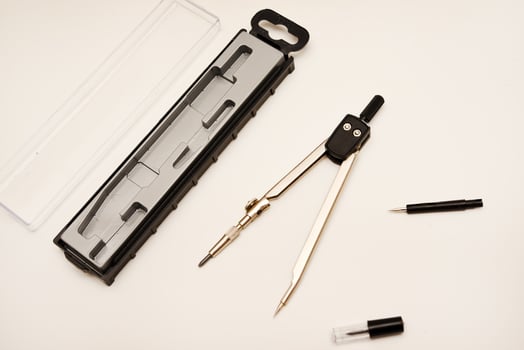 Black compasses on a white background. A drawing tool. photo