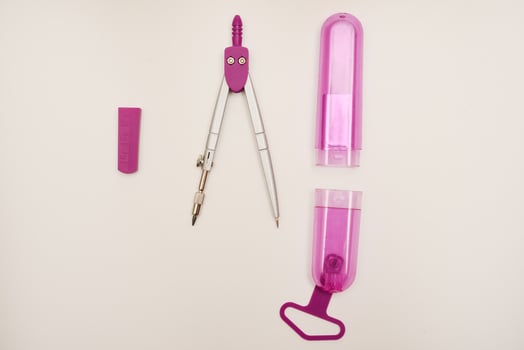 Pink compasses on a white background. A drawing tool. photo
