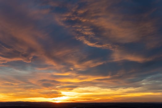 Sunset illuminates the sky with vibrant colors over a tranquil landscape during golden hour photo