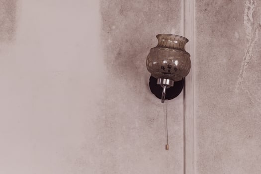 Unique vintage wall lamp hanging on a textured wall in a dimly lit room enhancing the cozy atmosphere photo