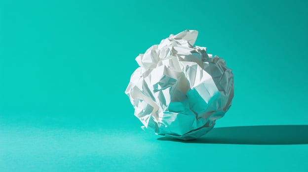 Crumpled Paper Ball in aqua blue background and mirror photo