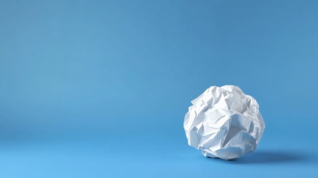 Crumpled Paper Ball on blue background minimal photo