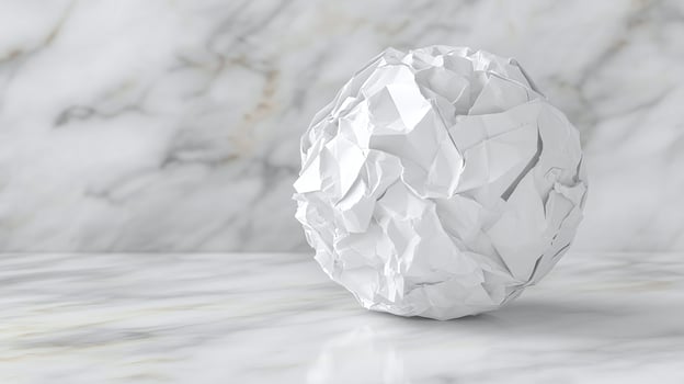 Crumpled Paper Ball on white marble wall photo