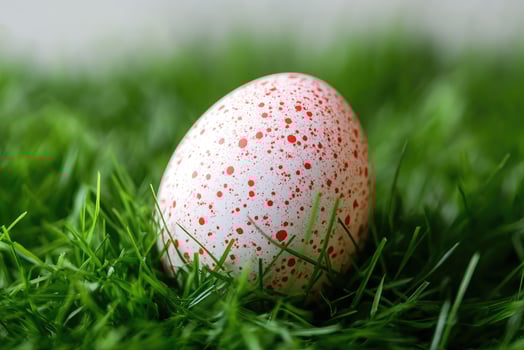 Decorated easter egg hiding in green grass photo
