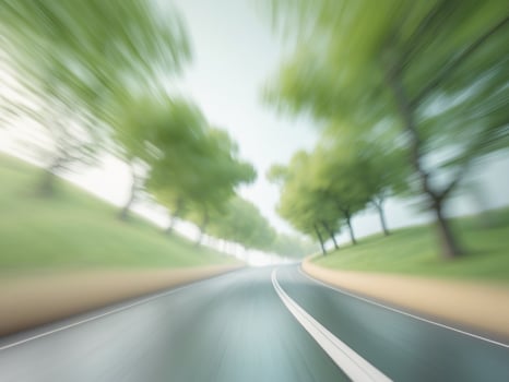 Motion blurred image of a road with trees and grass photo