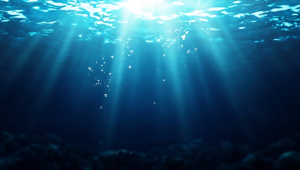 Underwater scene with sunlight rays illuminating the ocean depths. photo