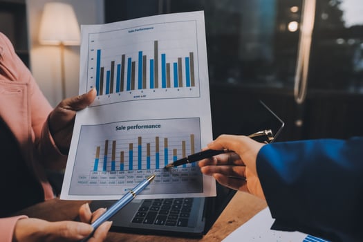 Business people holding papers with graphs on them photo