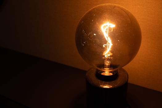 Vintage Light Bulb Glow. Warm Light Bulb in Dark. Illuminated Light Bulb. Retro Lighting Ambiance. Copy space. photo