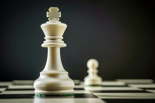 A white chess piece is sitting on a black and white chess board photo