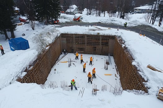 A group of workers are working on a large hole in the snow photo