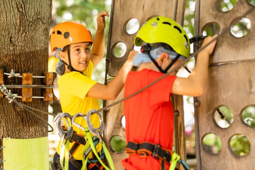Cute children. Boy and girl climbing in a rope playground structure at adventure park photo