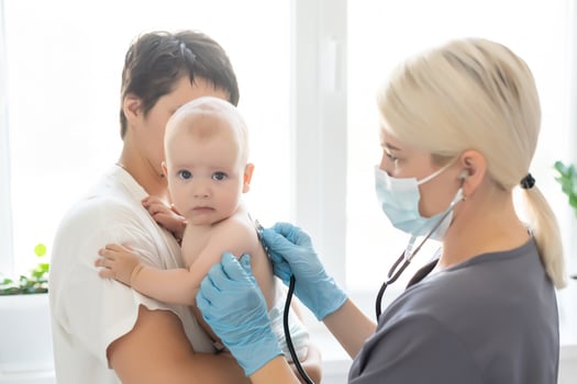 doctor with newborn on a white photo
