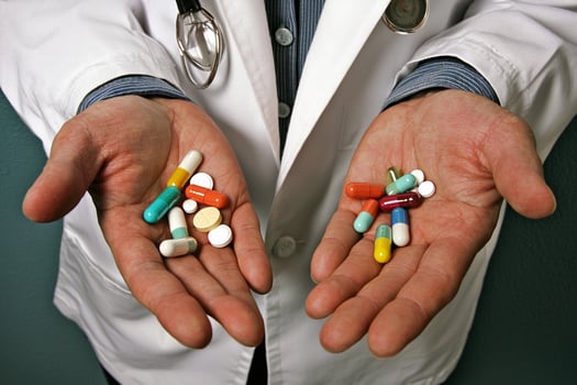 A doctor holding a handful of pills photo