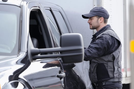 A man in a uniform is standing next to a truck photo