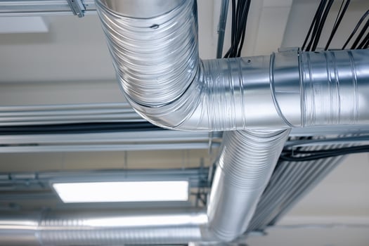 Pipes and wires in a room with a ceiling fan photo