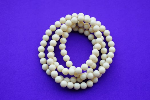 Holy lucky charm bead bracelets amulets on blue background. Concept, faith, beauty and fashion accessory. Handmade jewelry amulet, wearing for good luck. photo