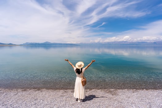 Young woman traveler relaxing and enjoying summer at beautiful sayram lake in Xinjiang, China photo