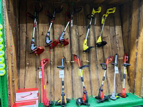 Kyiv, Ukraine - January 03, 2025 Display of electric grass trimmers in a store with wooden wall background photo