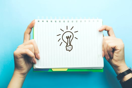 light bulb on notepad on woman hand photo