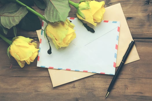 yellow rose with letters on table photo