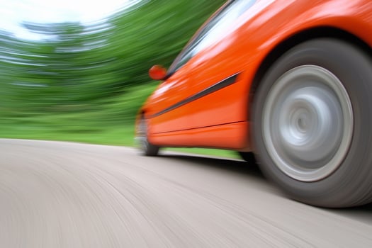 A blurry image of a car speeding down the road photo