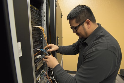 A man in glasses working on a server photo