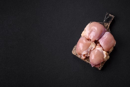 Fresh raw chicken thigh fillets with salt, spices and herbs photo