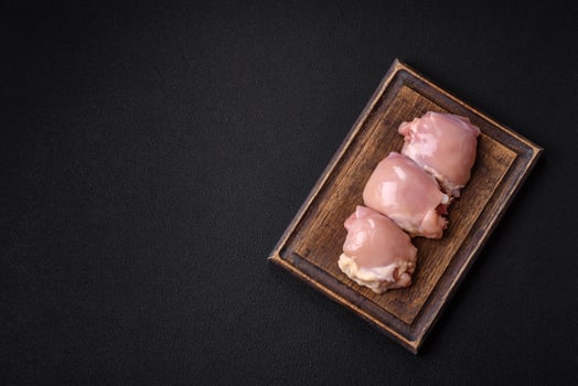 Fresh raw chicken thigh fillets with salt, spices and herbs photo