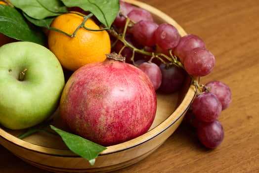 A Colorful Assortment of Fresh, Ripe Fruits Arranged Vibrantly in a Beautiful Wooden Bowl photo