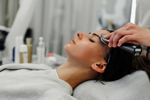 Woman receiving facial treatment in modern spa during daytime session for skincare relaxation photo