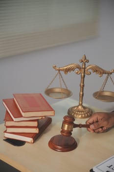 A person holding a gavel and a book on a desk photo