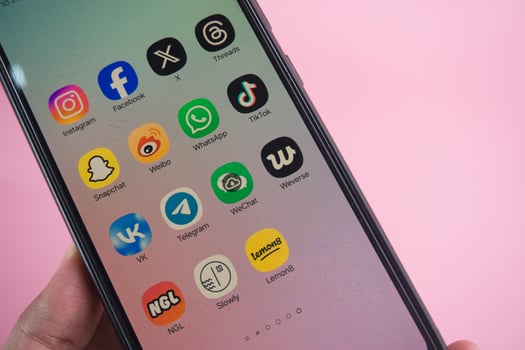 Close-Up of Smartphone Displaying Popular Social Media Applications on Pink Background photo