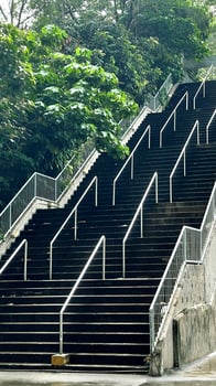 Vertical outdoor urban street and staircases with green trees photo