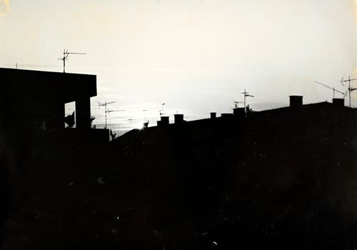 A black and white photo of a building with a sky in the background