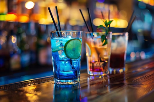 Three different colored drinks are sitting on a bar photo