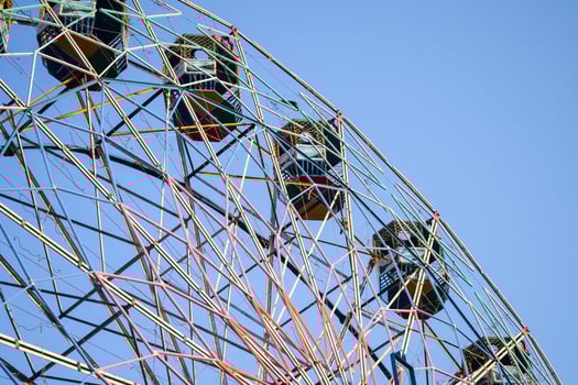 Closeup of multi-coloured Giant Wheel during Dussehra Mela in Delhi, India. Bottom view of Giant Wheel swing. Ferris wheel with colourful cabins during evening time. photo